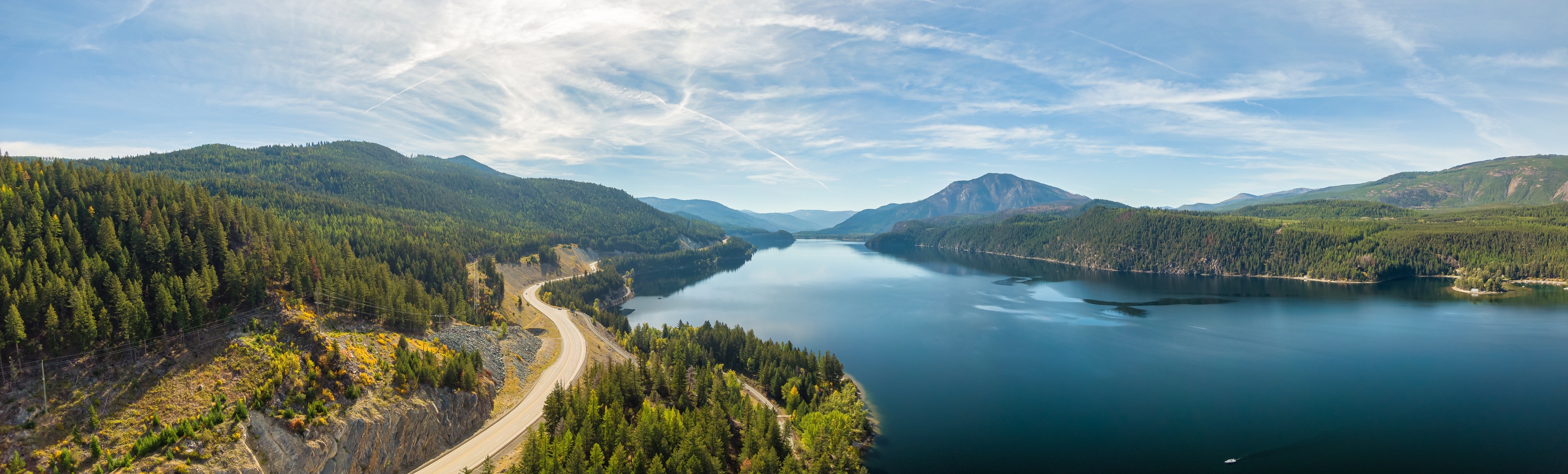 A view of the water, trees and wandering road in Kootenay, BC